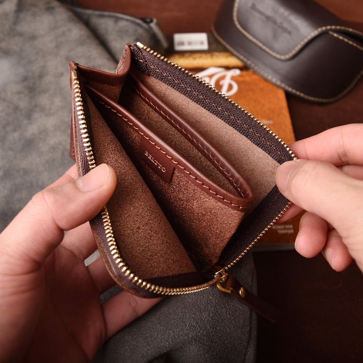 An empty leather zipper wallet with a soft suede interior and multiple compartments visible. Here are 5 smart ways to control emotional spending